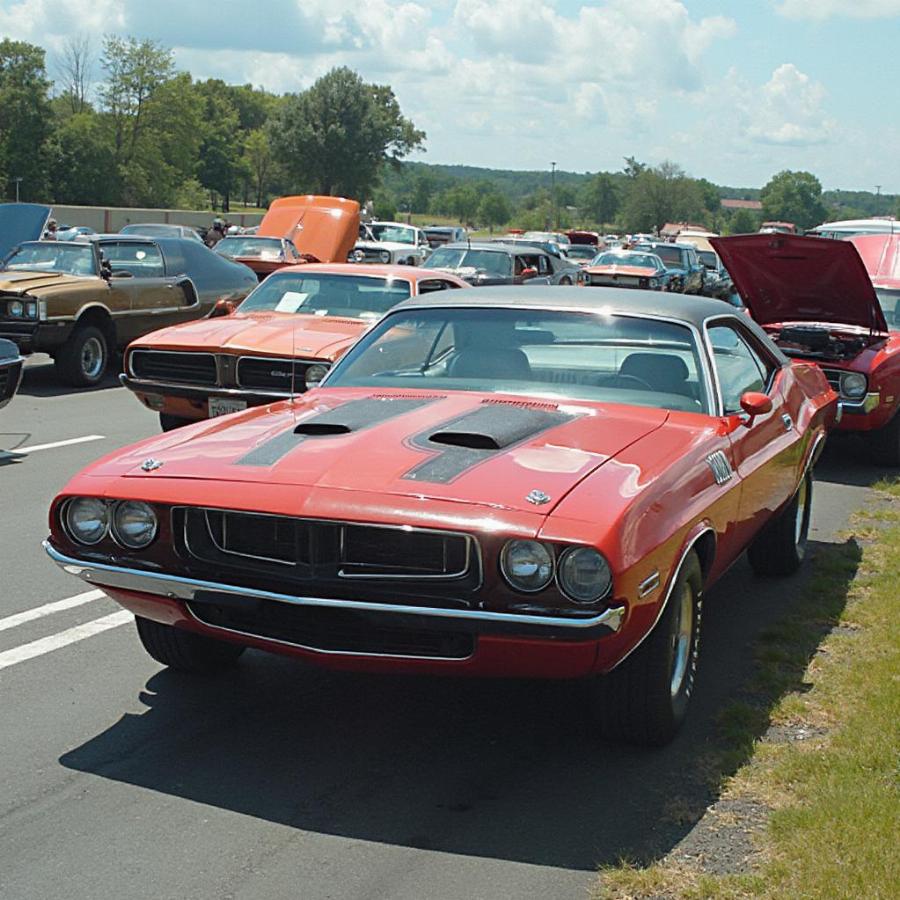 Several classic muscle cars, including a Dodge Challenger 440, gathered at a car meet.