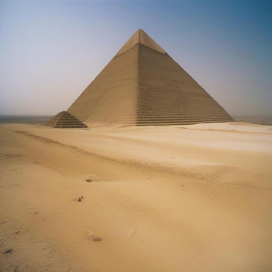 The Great Pyramid of Giza, the last remaining ancient wonder, against a clear blue sky.