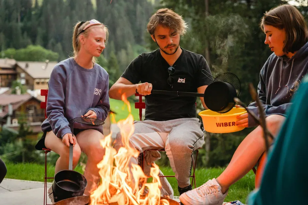 Abenteuerhotels Berghaus Schroecken Lagerfeuer mit Jugendlichen