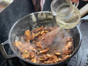 Ablöschen des angebratenen Boeuf Stroganoff mit Weißwein in der Pfanne