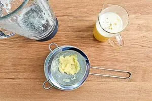 Abseihen des frisch gemixten Ingwer Shots durch ein feines Sieb, um eine glatte Konsistenz zu erhalten