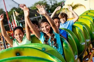 Achterbahnfahrt in einem deutschen Freizeitpark mit lachenden Menschen, ein spannendes Ausflugsziel im Juli.