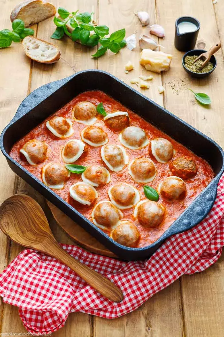 Alle Zutaten für das Hackbällchen Rezept: Hackfleisch, Tomaten, Mozzarella und frische Kräuter bereitgestellt