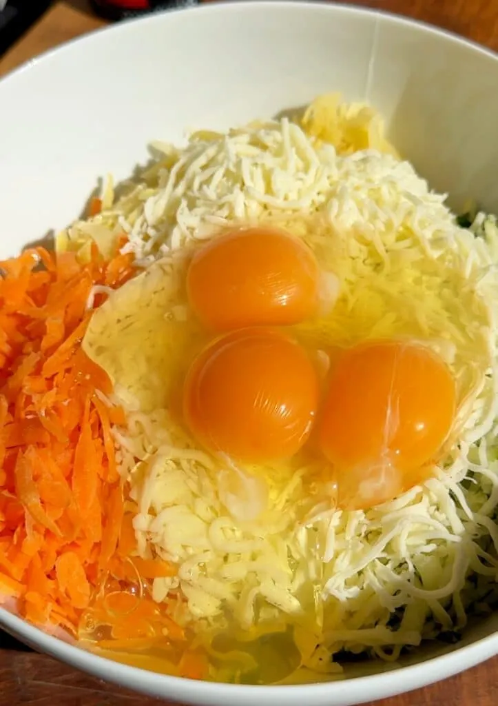 Alle Zutaten für die Low Carb Wrap-Basis – geriebenes Gemüse, Eier, Mozzarella und Gewürze – in einer großen Schüssel