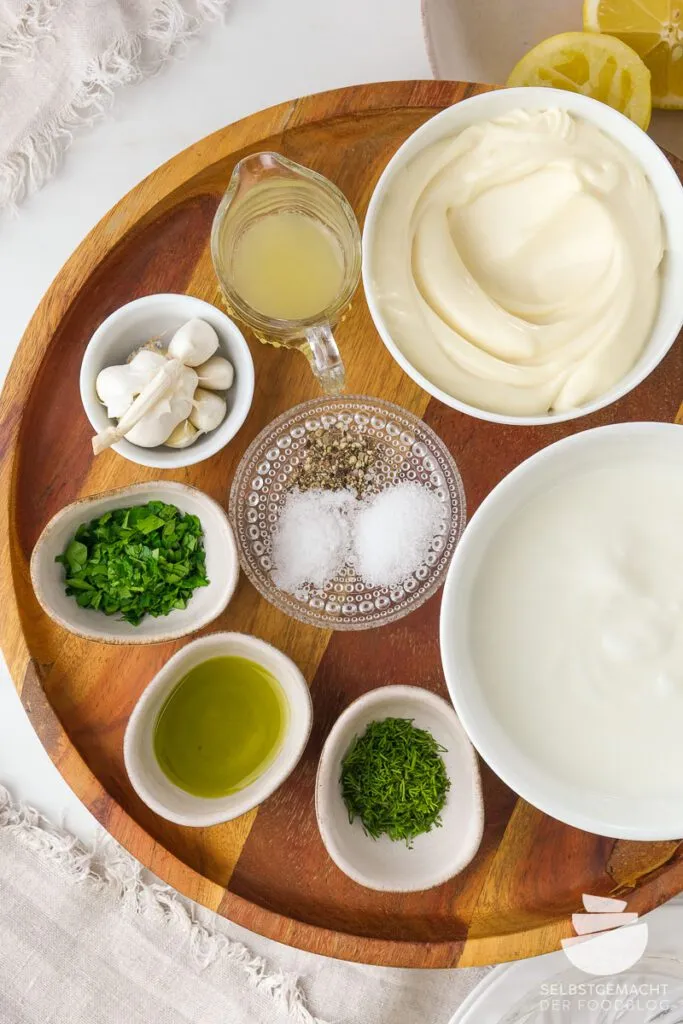 Alle Zutaten für die selbstgemachte original türkische Dönersoße auf einem Holzbrett.