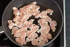 Anbraten von Hähnchenstreifen in einer Pfanne mit Pflanzenöl