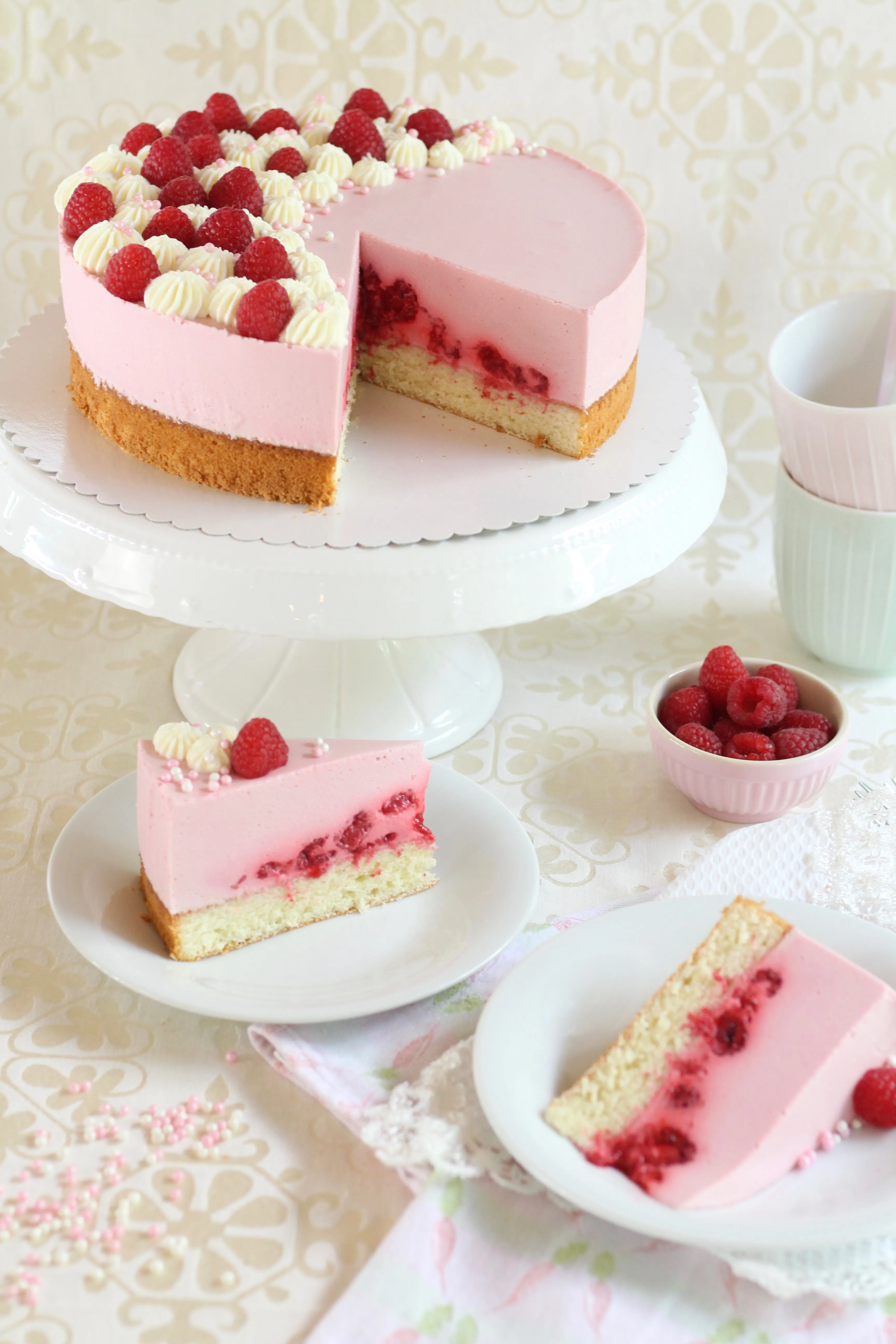 Anschnitt einer Himbeertorte mit Sahne und Himbeeren