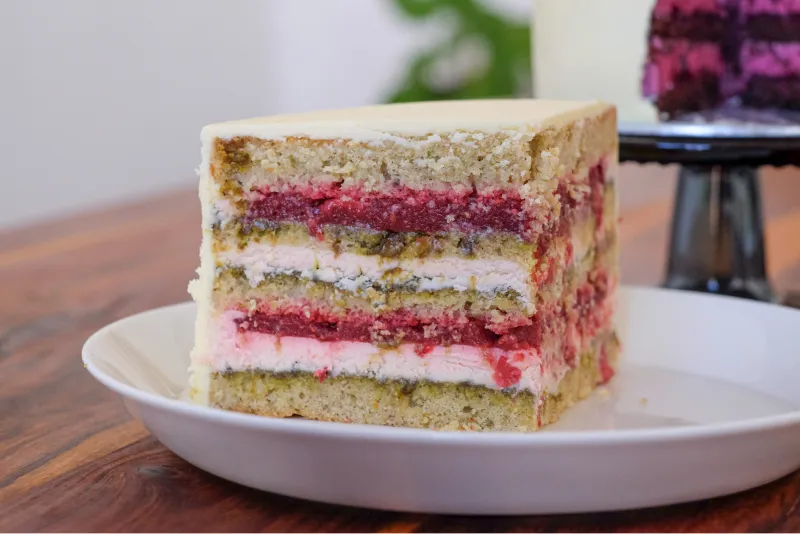 Anschnitt einer Probe-Hochzeitstorte mit Pistazienböden, Erdbeercreme und Fruchfüllung