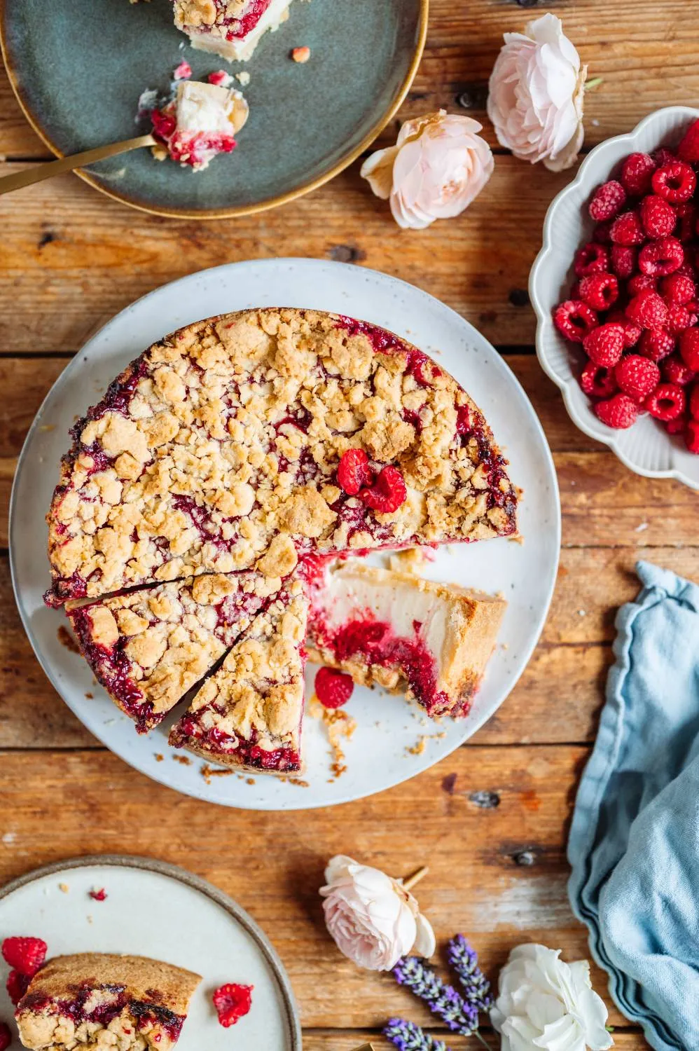 Ansicht des fertig gebackenen Himbeer-Joghurt-Cheesecakes von oben, mit reichlich Streuseln und Himbeeren