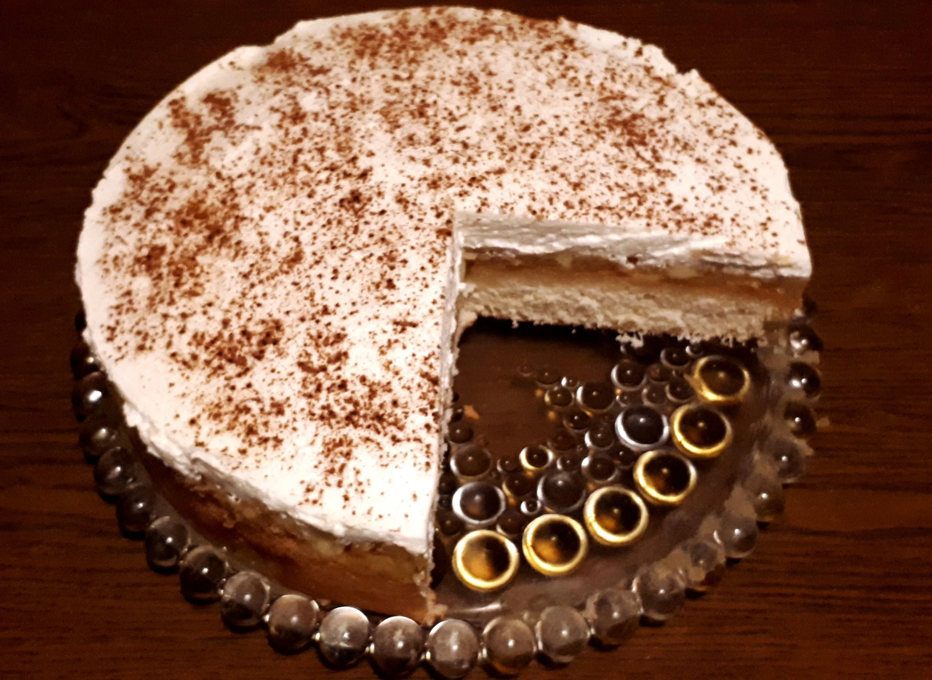 Ansicht einer fertigen Zimt-Quark-Sahne-Torte, reichlich mit Zimt bestreut und verzehrfertig.