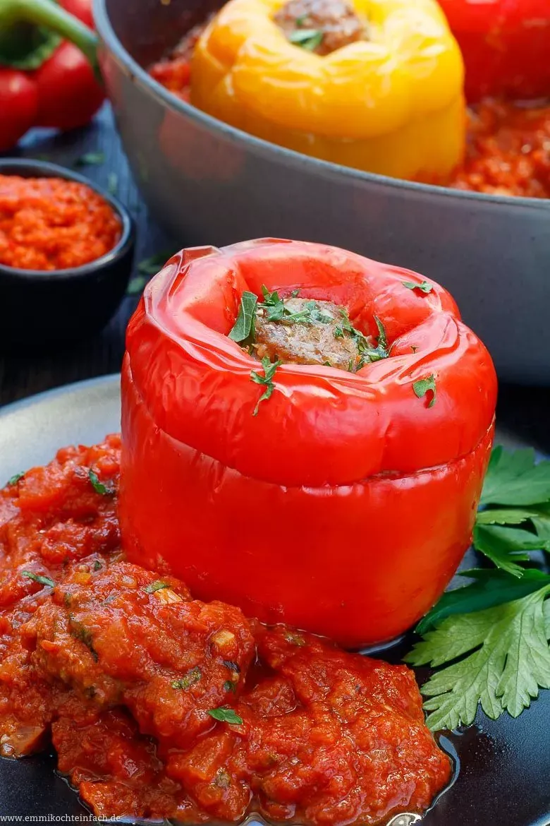 Ansicht von oben auf eine gefüllte Paprikaschote mit Hackfleisch und Tomatensoße in einem Schmortopf