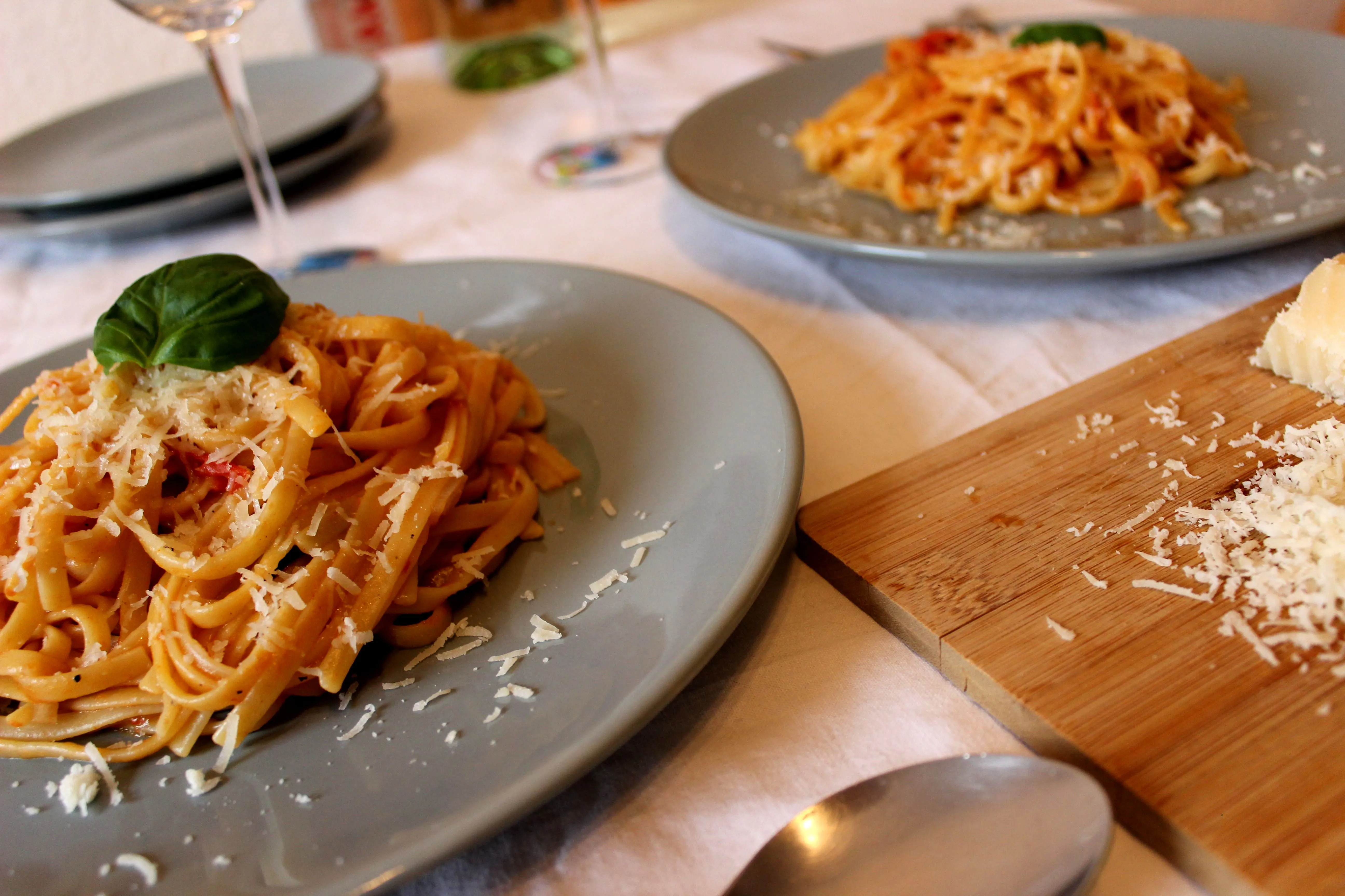 Ansprechende One-Pot Pasta angerichtet mit frischen Basilikumblättern und geriebenem Parmesan