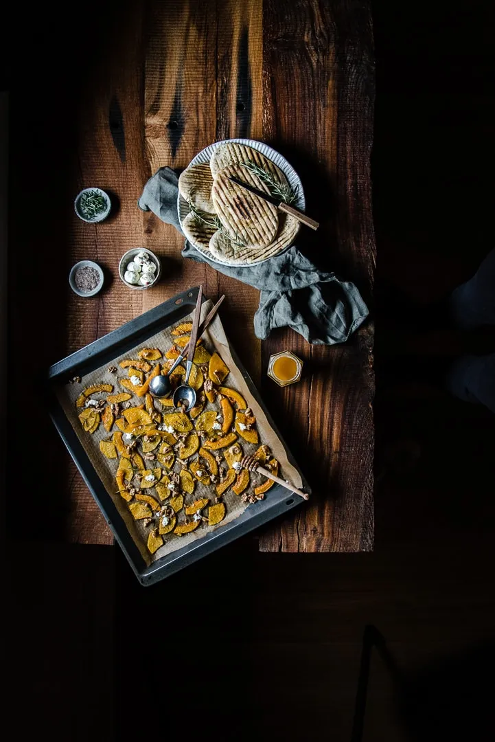 Ansprechende Präsentation von Butternut Kürbis aus dem Ofen mit Walnüssen, Ziegenkäse und Rosmarin