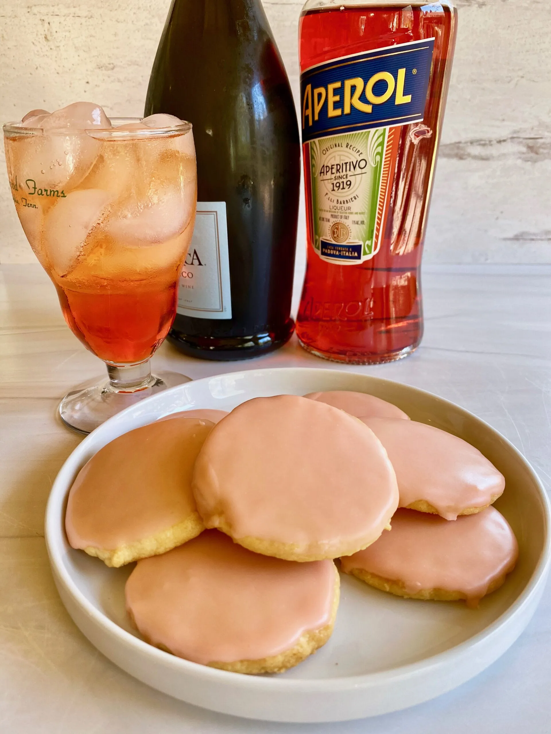 Aperol Spritz Kekse mit fruchtiger Glasur und Orangenscheibe