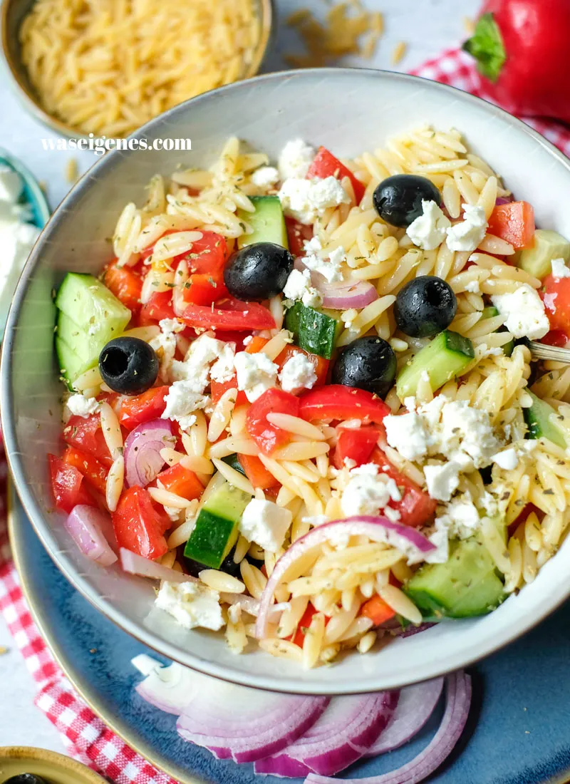 Appetitlich angerichteter griechischer Kritharaki-Salat in einer Keramikschale, bereit zum Servieren.