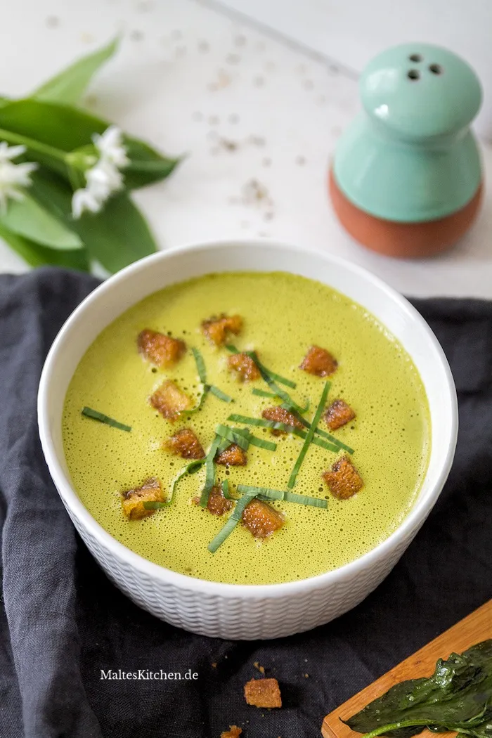Appetitliche Bärlauchsuppe, garniert mit knusprigen Bärlauch-Croûtons und frischen Kräutern, perfekt als Vorspeise in der deutschen Saisonküche.