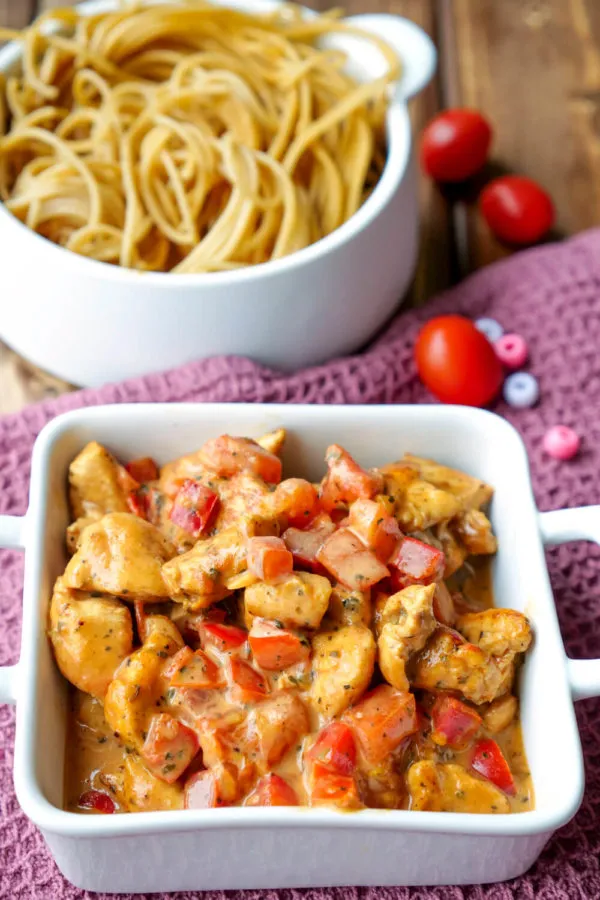 Appetitliche Hähnchen-Paprika-Pfanne mit cremiger Sauce, serviert mit Spaghetti, ein beliebtes schnelles Hähnchenrezept.
