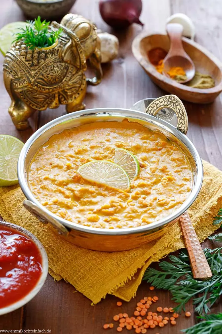 Appetitliche Portion vegane rote Linsensuppe in einer hellen Keramikschale, von oben fotografiert, um ihre reichhaltige Textur und Garnierung zu zeigen.