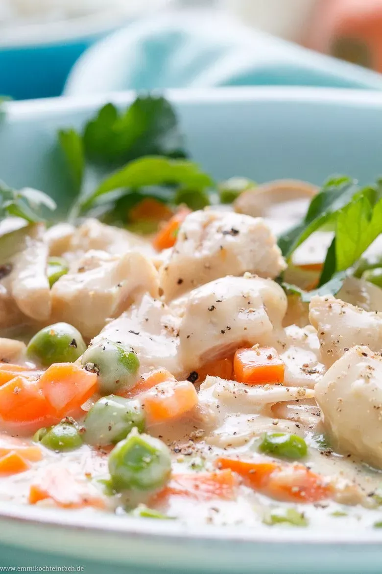 Appetitliches Hühnerfrikassee in einer Schale, bestreut mit frischer Petersilie, bereit zum Servieren