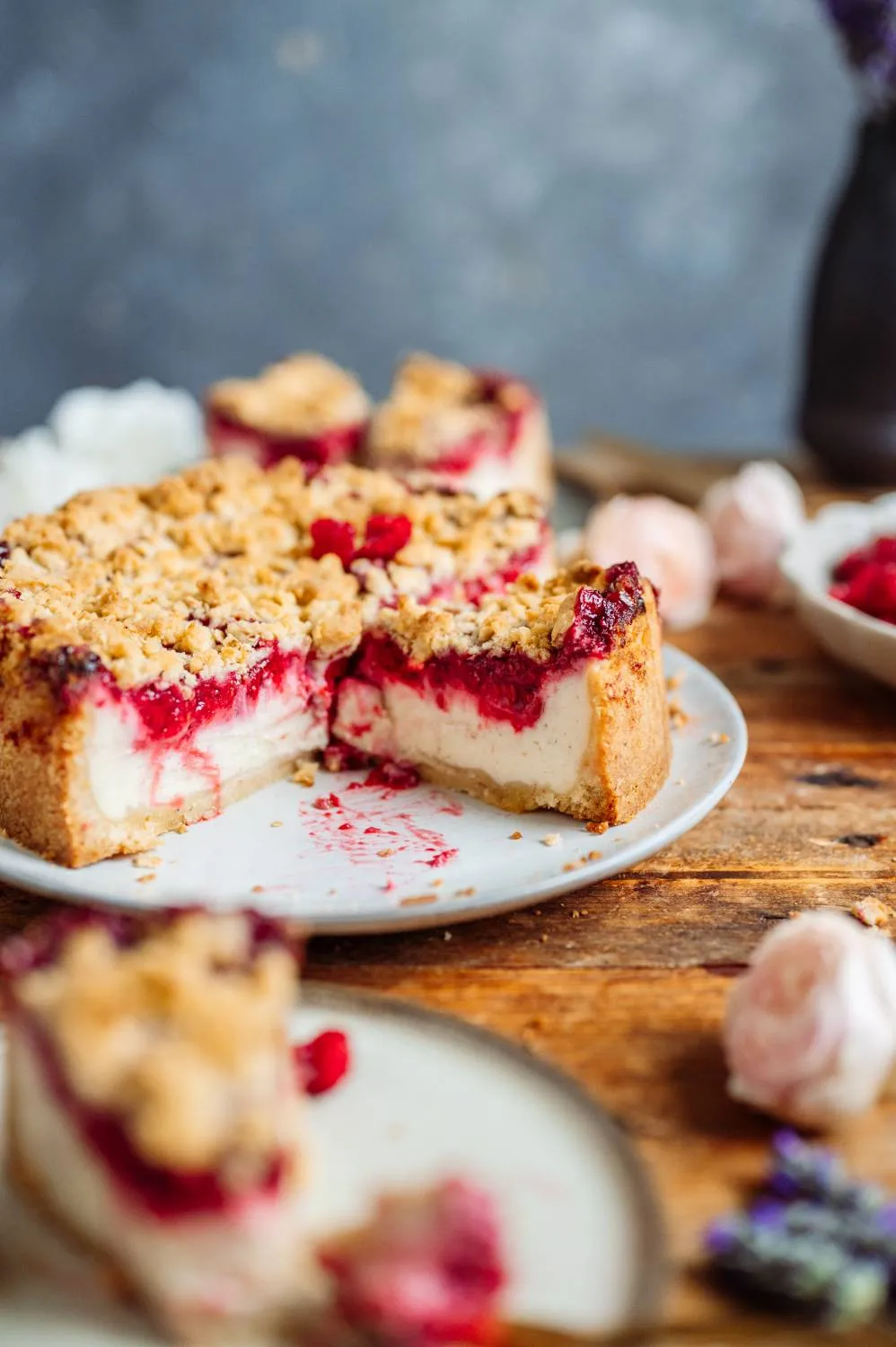 Appetitliches Stück Himbeer-Streusel-Joghurt-Cheesecake mit frischen Beeren, ein festlicher und einfacher Geburtstagskuchen