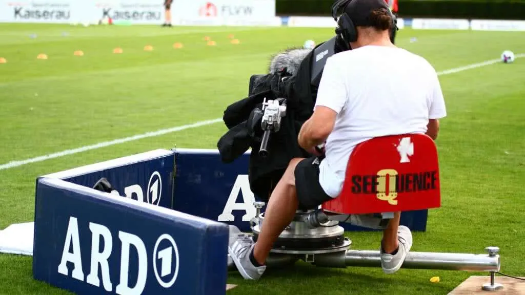 ARD-Kamera und Kamerateam am Spielfeldrand, bereit für die Liveübertragung des Finaltags der Landespokale 2022, unterstreicht die hohe Medienpräsenz des Amateurfußballs.