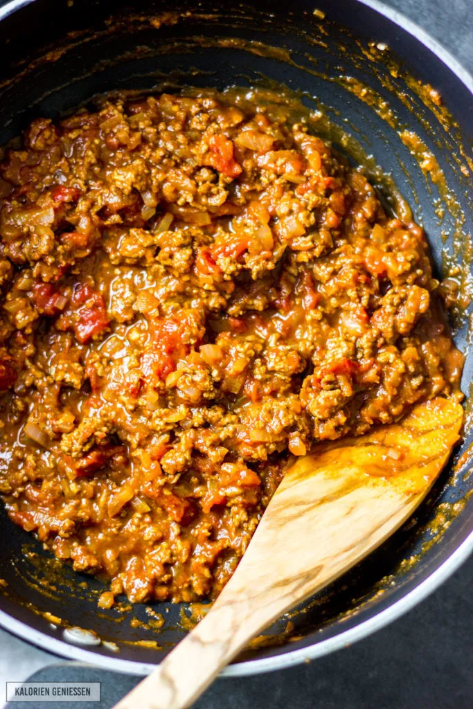 Aromatische Bolognese-Sauce mit magerem Rindertatar köchelt in der Pfanne für die gesunde Lasagne.