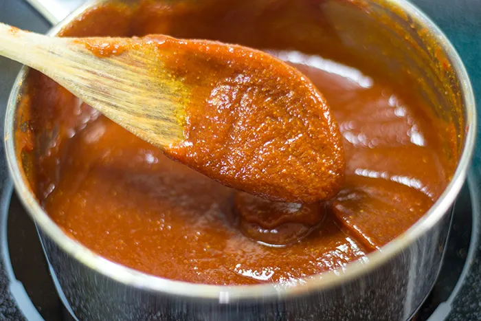 Aromatische Gewürze werden dem Ketchup für die Currywurst Soße hinzugefügt
