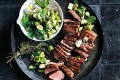 Aromatisches Kräuterlamm serviert mit frischem Olivensalat