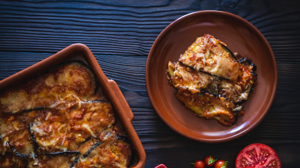 Auberginenauflauf "Parmigiana di Melanzane" mit geschmolzenem Käse und Ciabatta-Brot