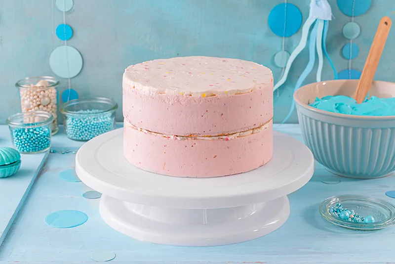 Auch die Sahnetuffs der oberen Torte werden glattgestrichen, um eine ebene Fläche für die Meerjungfrauen Torte zu schaffen.