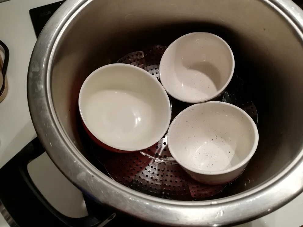 Aufbau für die Herstellung von alkoholfreiem Gin: Botanicals im Wasser, Dämpfeinsatz und Auffangschale