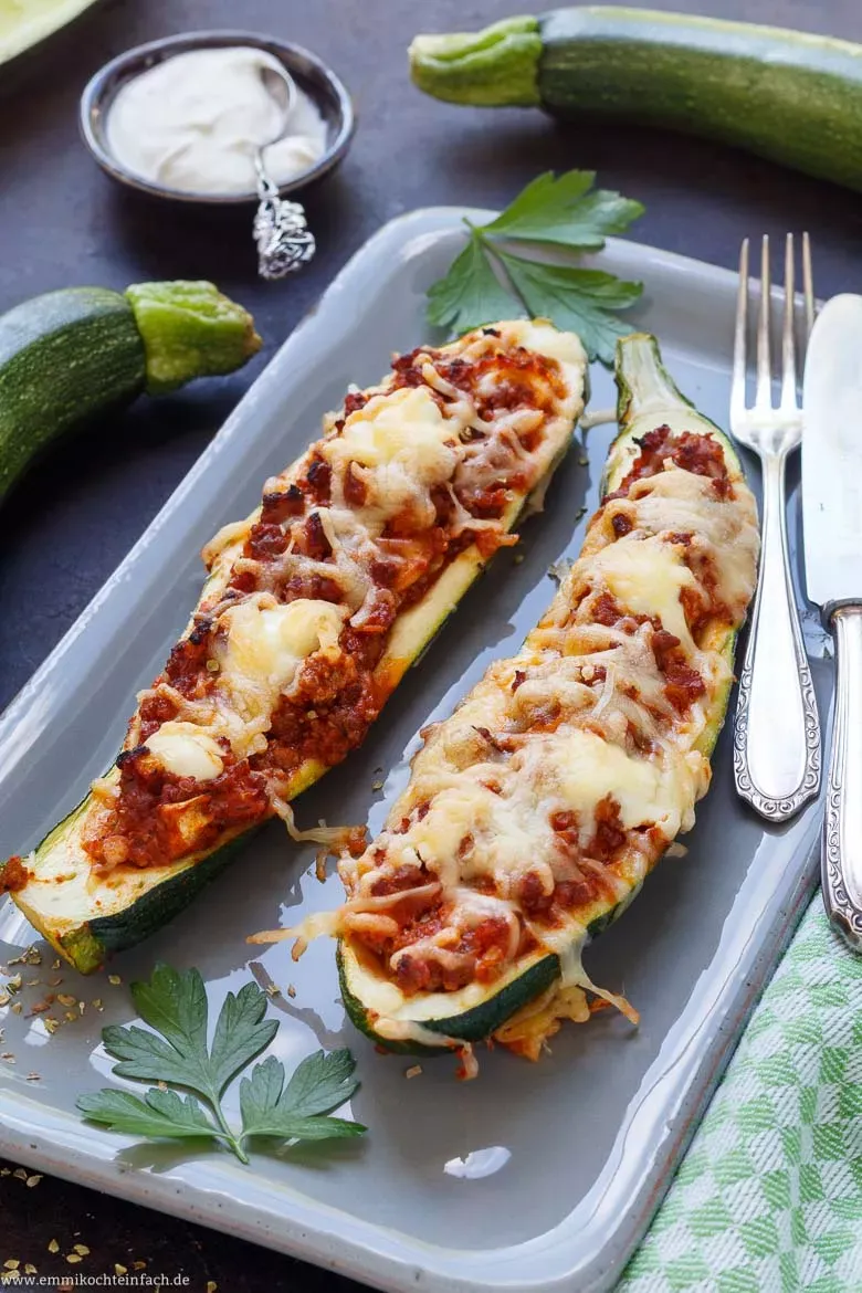 Ausgehöhlte Zucchinihälften auf einem Backblech, bereit zur Befüllung