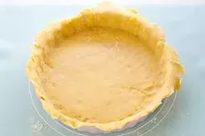 Ausgerollten Quiche Teig vorsichtig in die gefettete Backform legen.