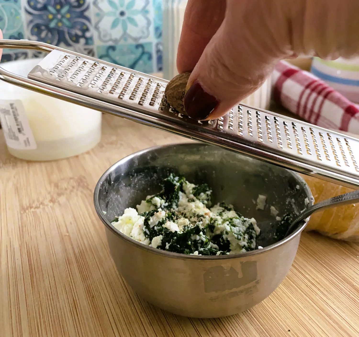 Ausgerollter Nudelteig mit platzierten Ricotta-Spinat-Füllungskugeln für Ravioli