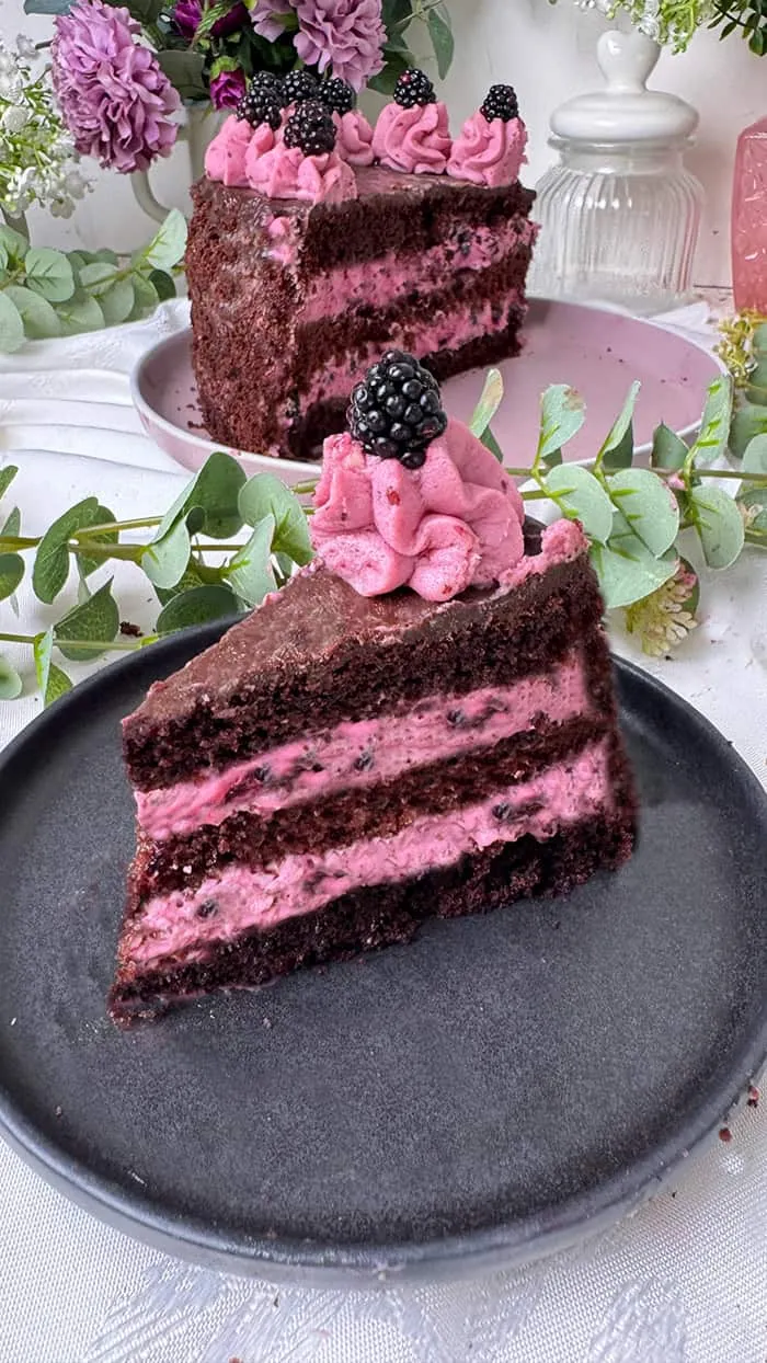 Ausgeschnittene Brombeer Sahne Torte, bereit zum Genießen, mit üppiger Beerendekoration
