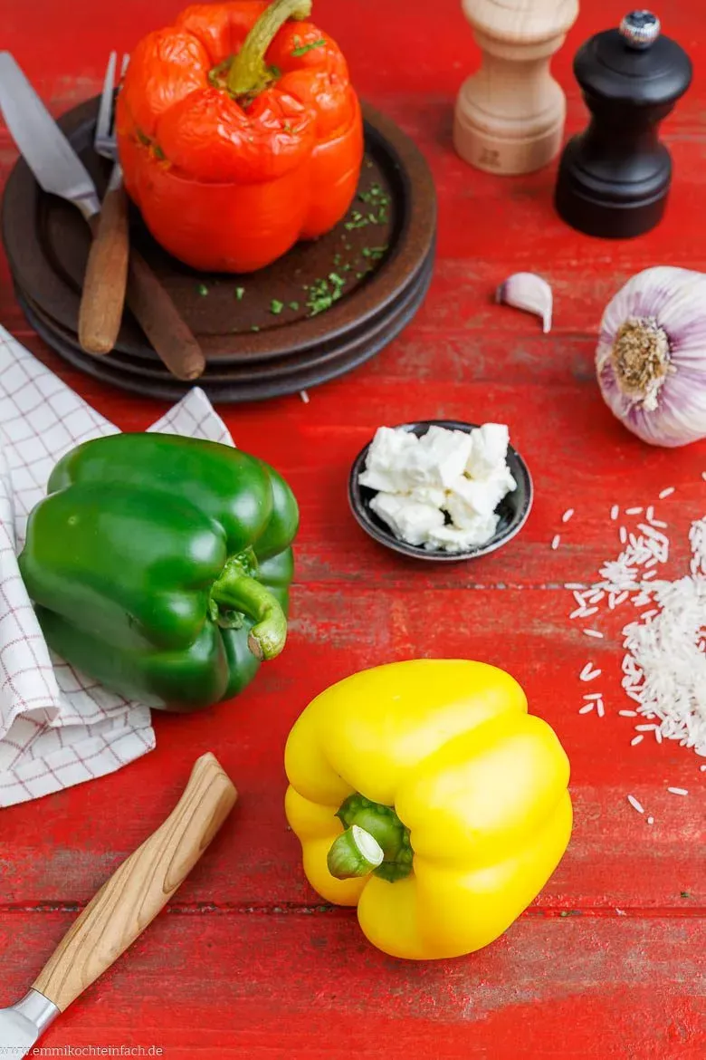 Auswahl frischer Zutaten wie Feta, Ajvar und Reis für die vegetarische Paprikafüllung.