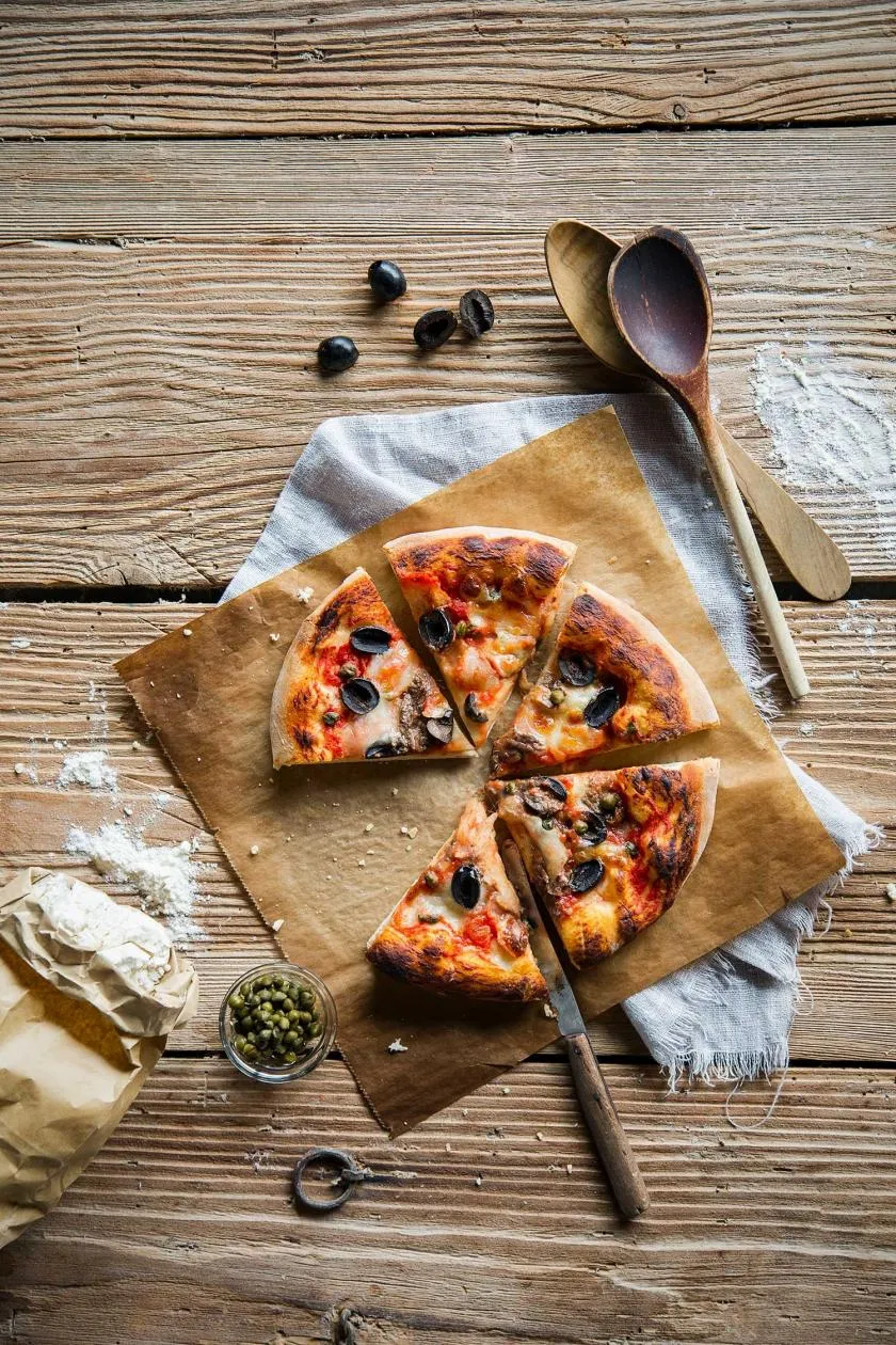 Authentische Pizza Napoli mit Kapern, Sardellen, Oliven und Tomatensauce.