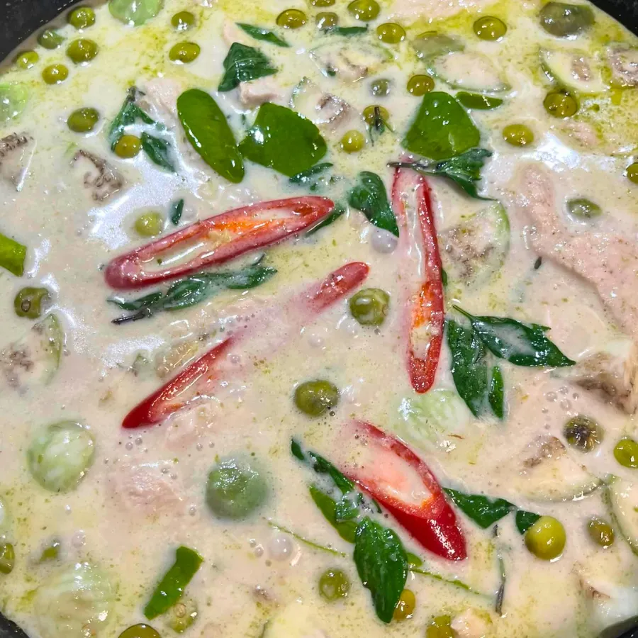 Authentisches Grünes Thai Curry in einer Schale mit Jasminreis und frischen Kräutern