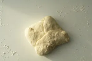 Baguette Teig falten: Darstellung der weiteren Schritte beim Einschlagen des Teigs von unten und top.