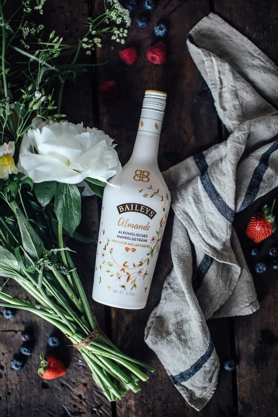 Baileys Almande Flasche auf Holzoberfläche mit Blumen