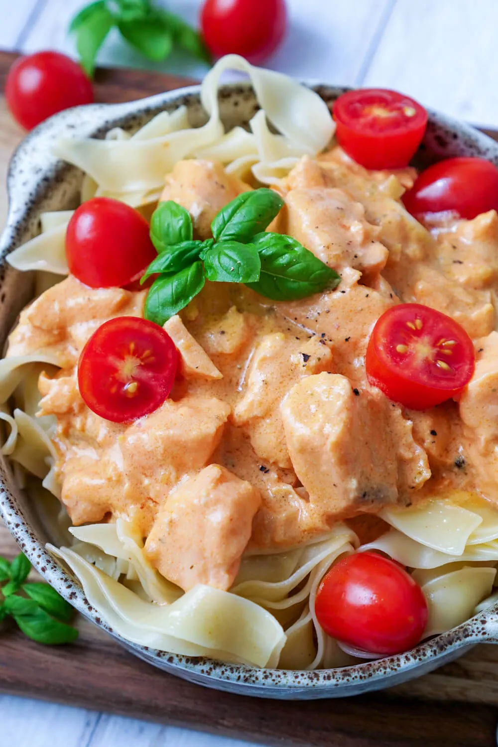 Bandnudeln mit Lachs, cremiger Sahnesauce und Tomaten in einer ansprechenden Schüssel