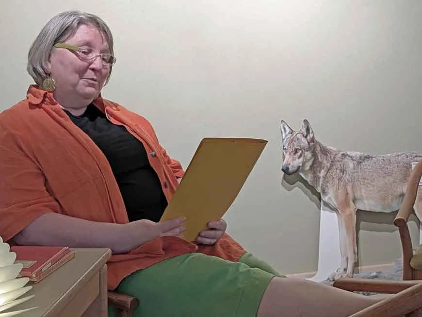 Barbara, die Gastgeberin, steht vor dem Wolfsbau-Kunstobjekt