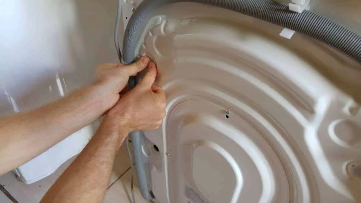 Beim Eindrücken der Abdeckkappen in die Löcher der Transportsicherung an der Rückseite einer Waschmaschine