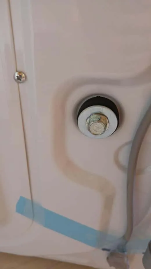 Beim Einsetzen eines Gewindebolzens in die Transportsicherung der Waschmaschine