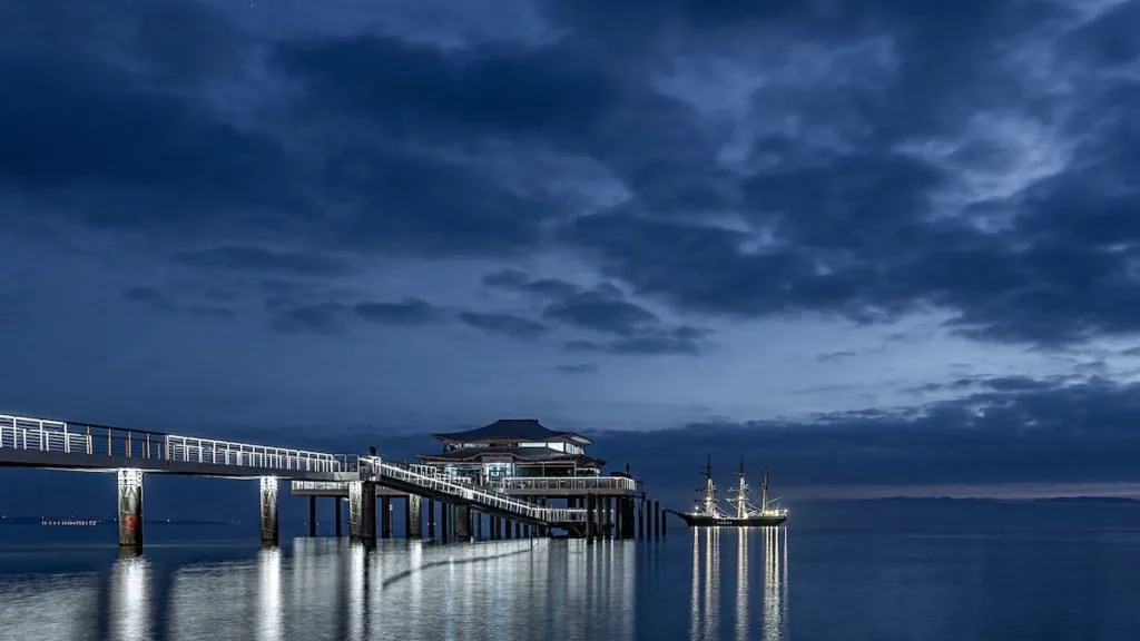 Beleuchtete Seebrücke in Travemünde mit Schiff in Norddeutschland ist ein beliebtes Reiseziel