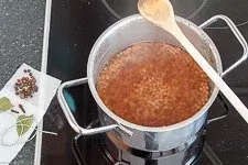 Berglinsen werden in einem Topf mit Wasser vorgekocht, mit einem Gewürzsäckchen daneben