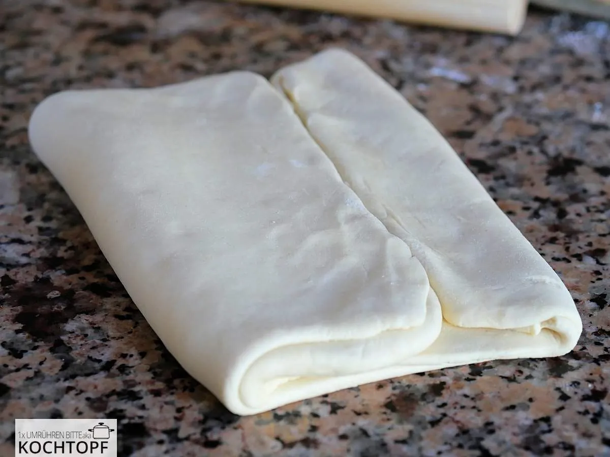 Blätterteig während des Tourierens, an einer Seite eingeschlagen, um die ersten Schichten zu bilden.