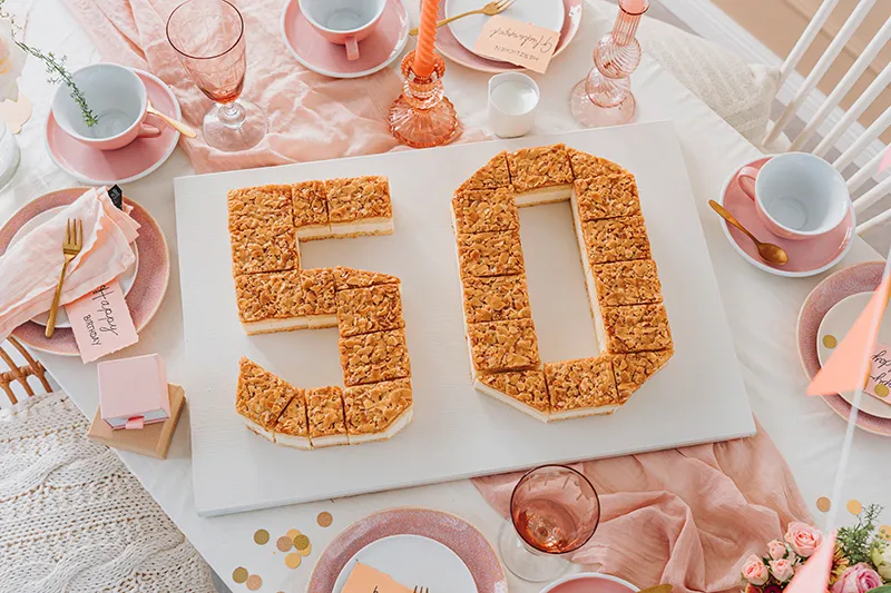 Blechkuchenstücke kunstvoll zu einer 50 geformt auf einer Platte, bereit zum Dekorieren