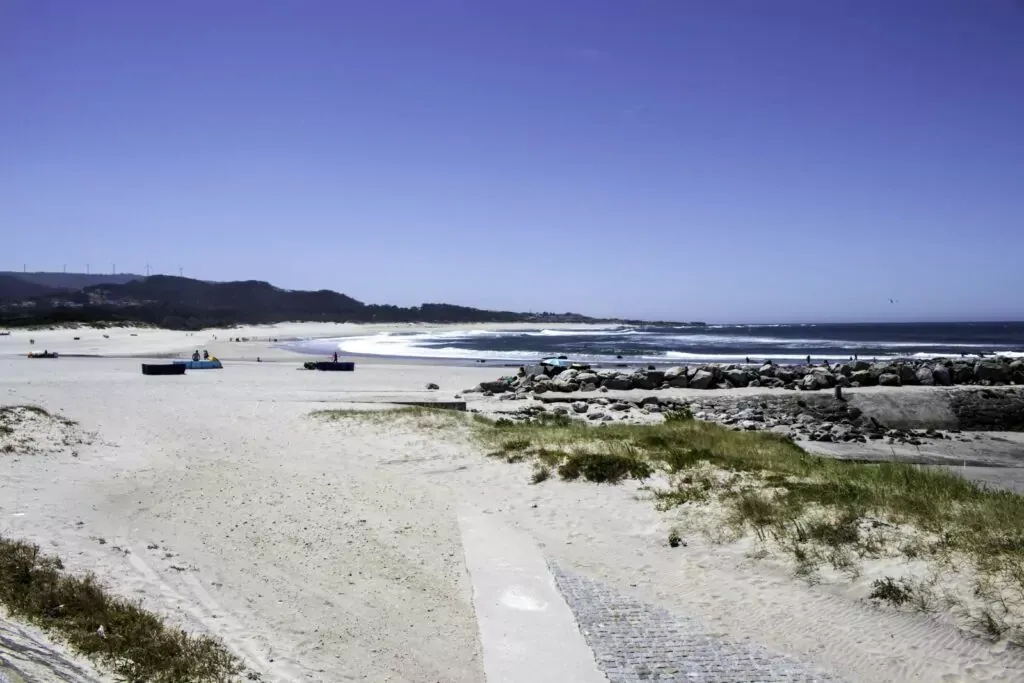 Blick auf den Strand Praia da Duna do Caldeirão mit Dünenlandschaft und blauem Himmel