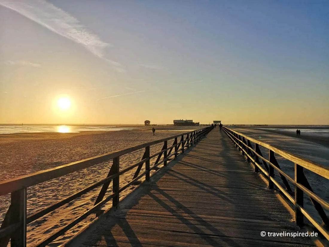 Blick auf die ikonischen Pfahlbauten am weiten Sandstrand von St. Peter-Ording, einem Top-Reiseziel für Unternehmungen an der Nordsee.